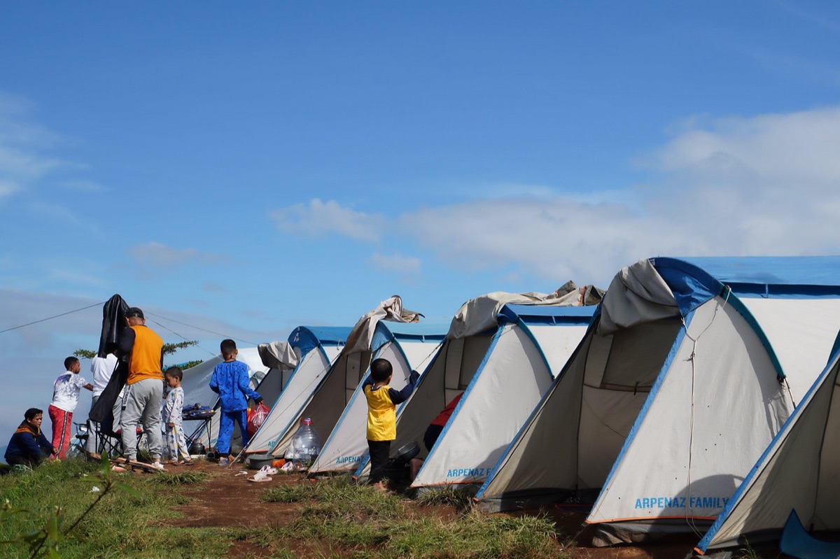 Essential camping gear including a tent and sleeping bag set up in nature