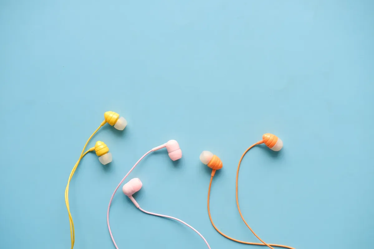 Vibrant earphones with a blue backdrop, perfect for tech visuals.