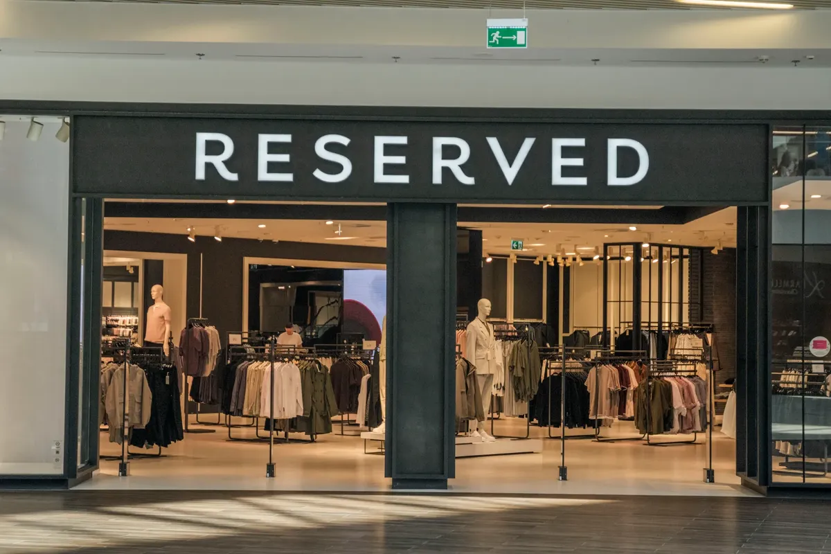 チャイニンな服店の入り口、にぎわうショッピングモール内に展示されているトレンドの衣料品