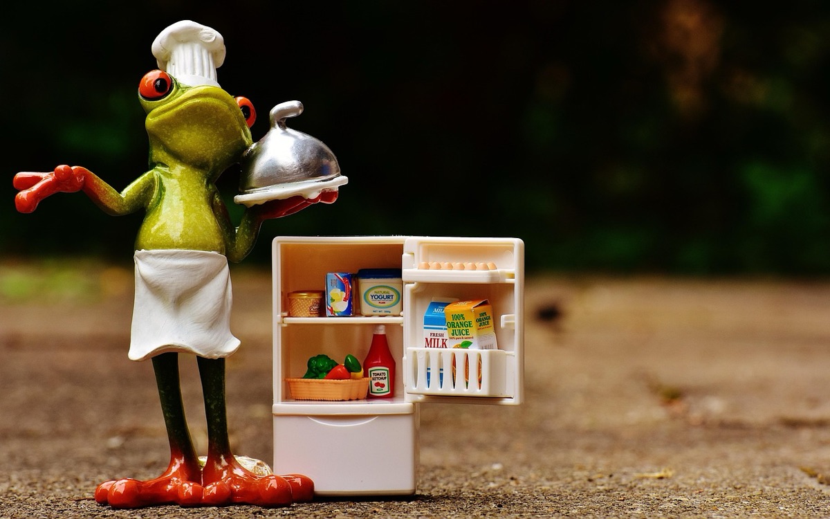 Person carrying a heavy grocery bag through a store with a refrigerator in the background
